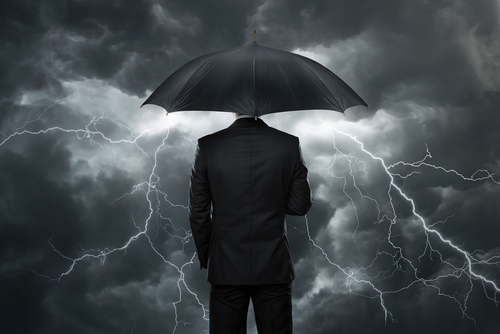 monochromatic image of person standing under an umbrella that has lightening coming from it